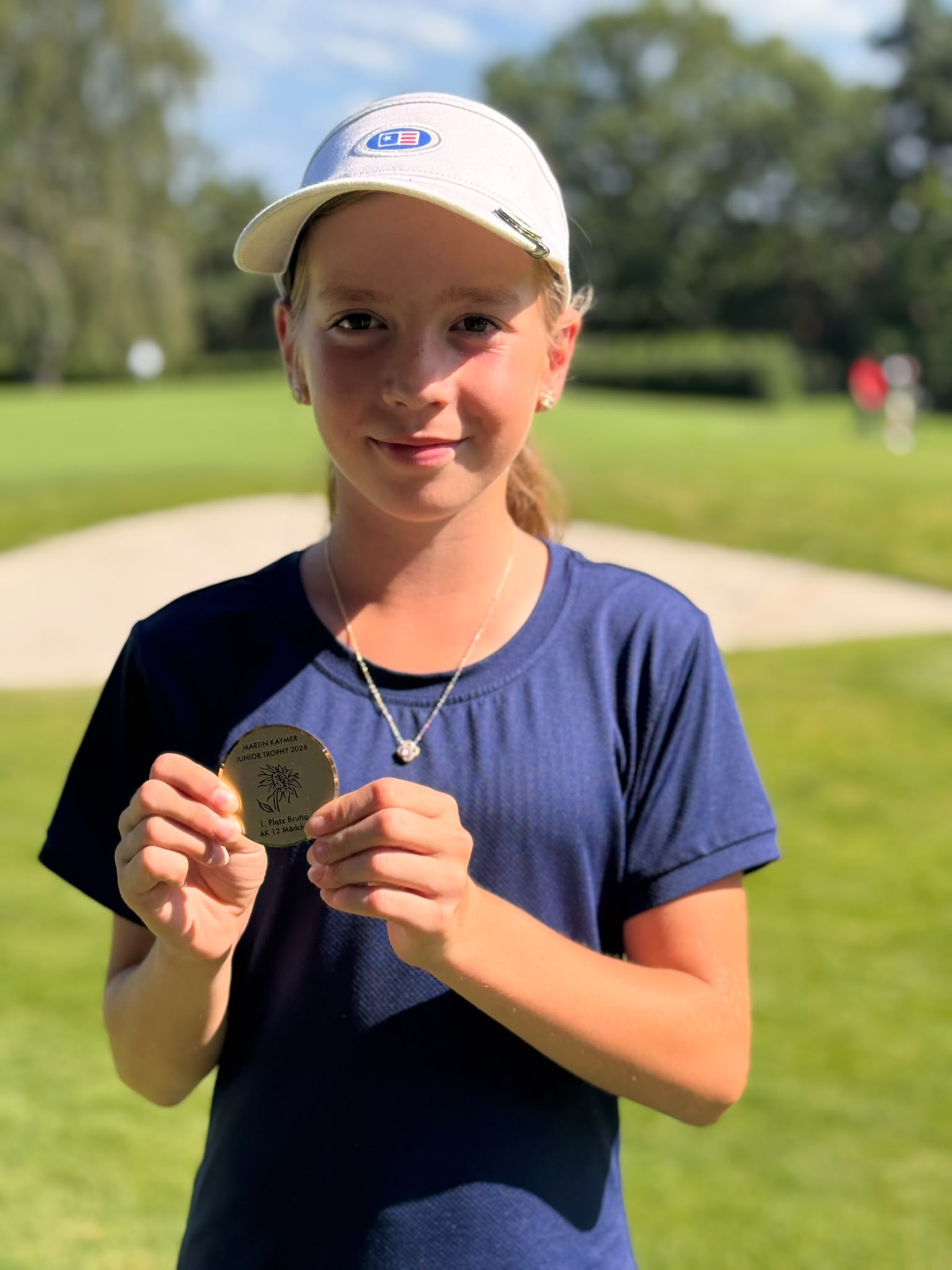 Louiza Sofie Menzel mit ihrer Medaille auf dem Golfplatz